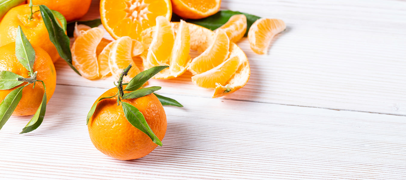 Whole clementine surrounded by pilled clementines
