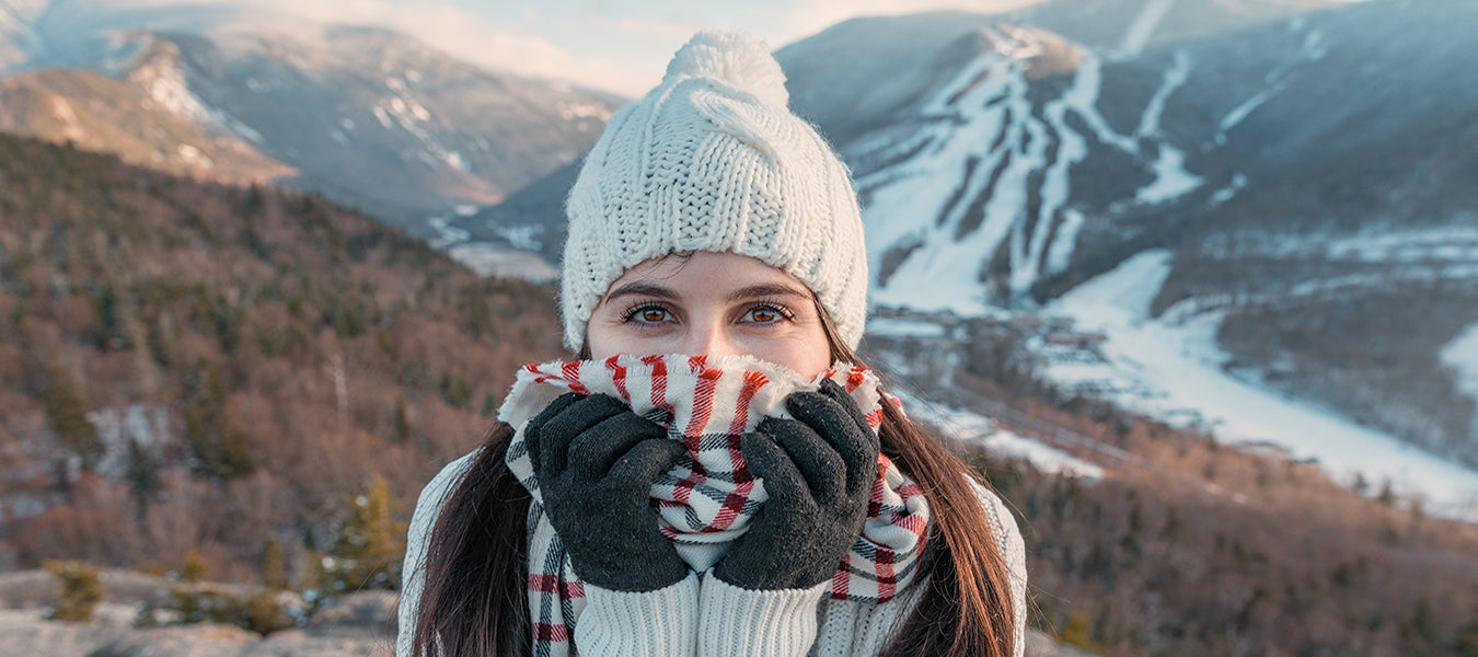 Woman in cold weather with hat and scarf in the mountains