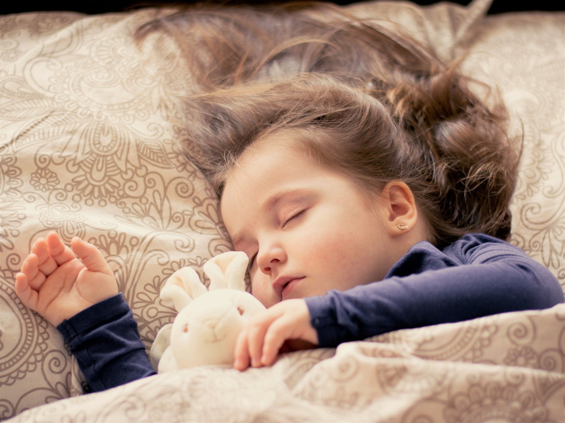 Little girl sleeping with her stuffed bunny
