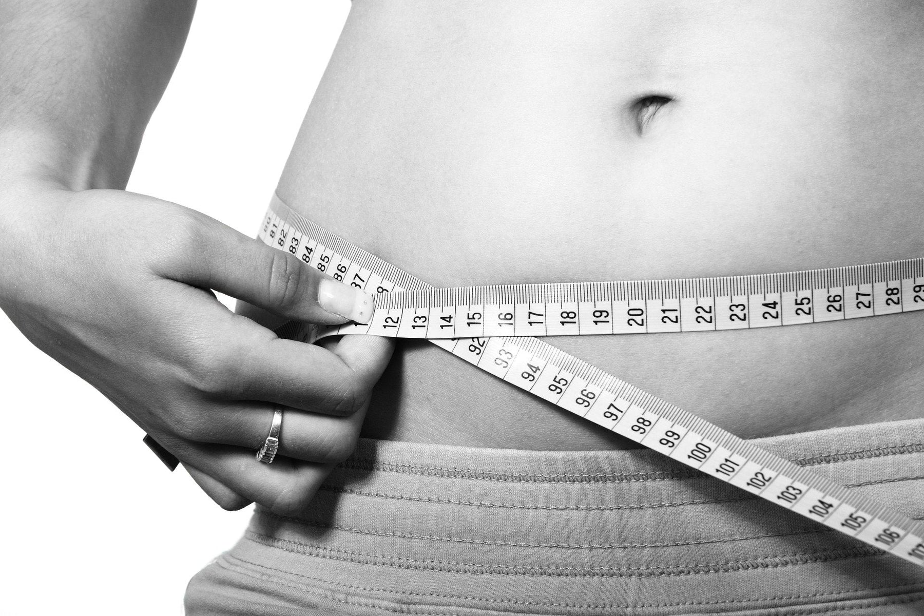 Woman measuring her belly