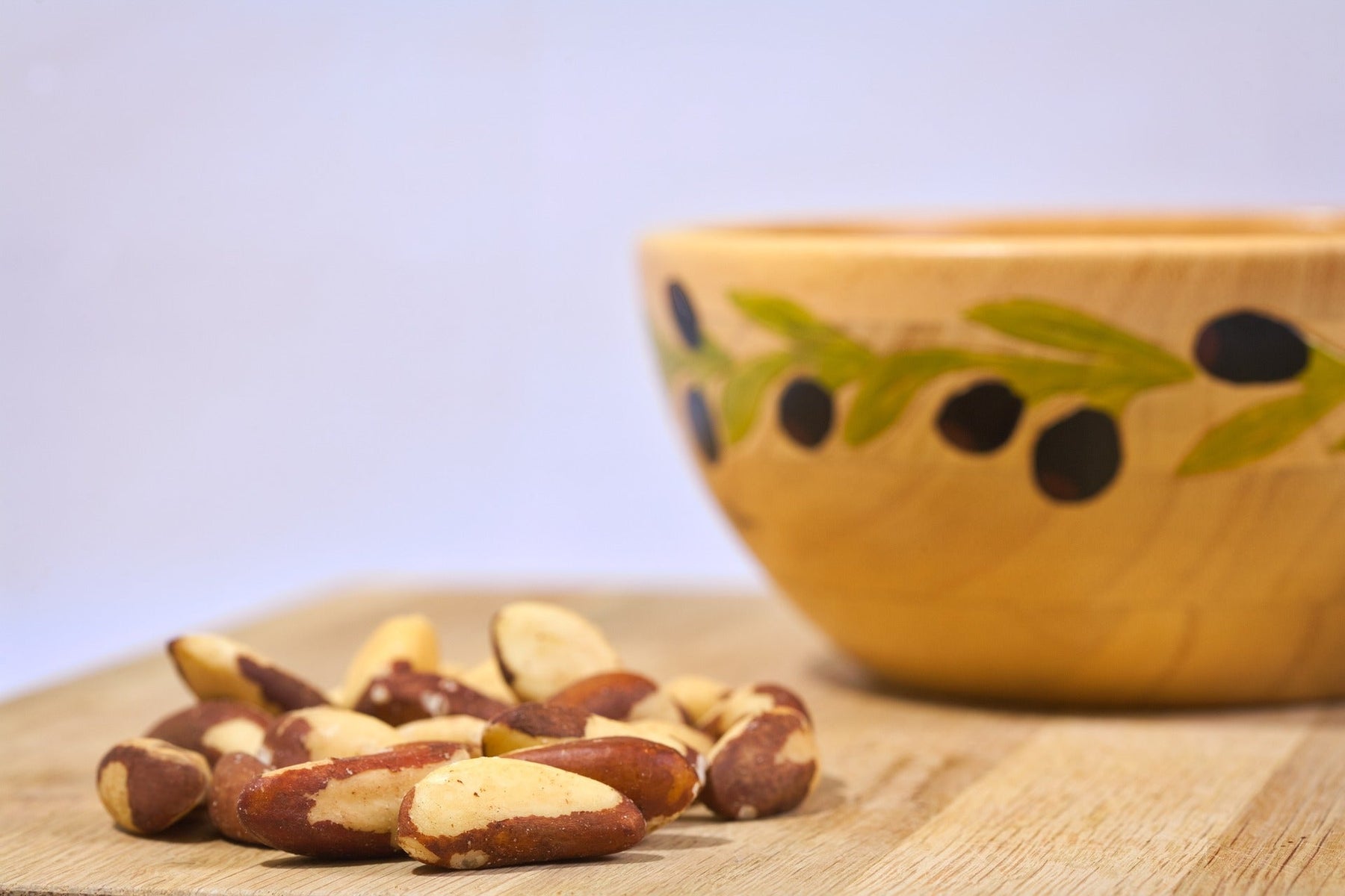 Brazilian nuts on a wooden table next to a bowl
