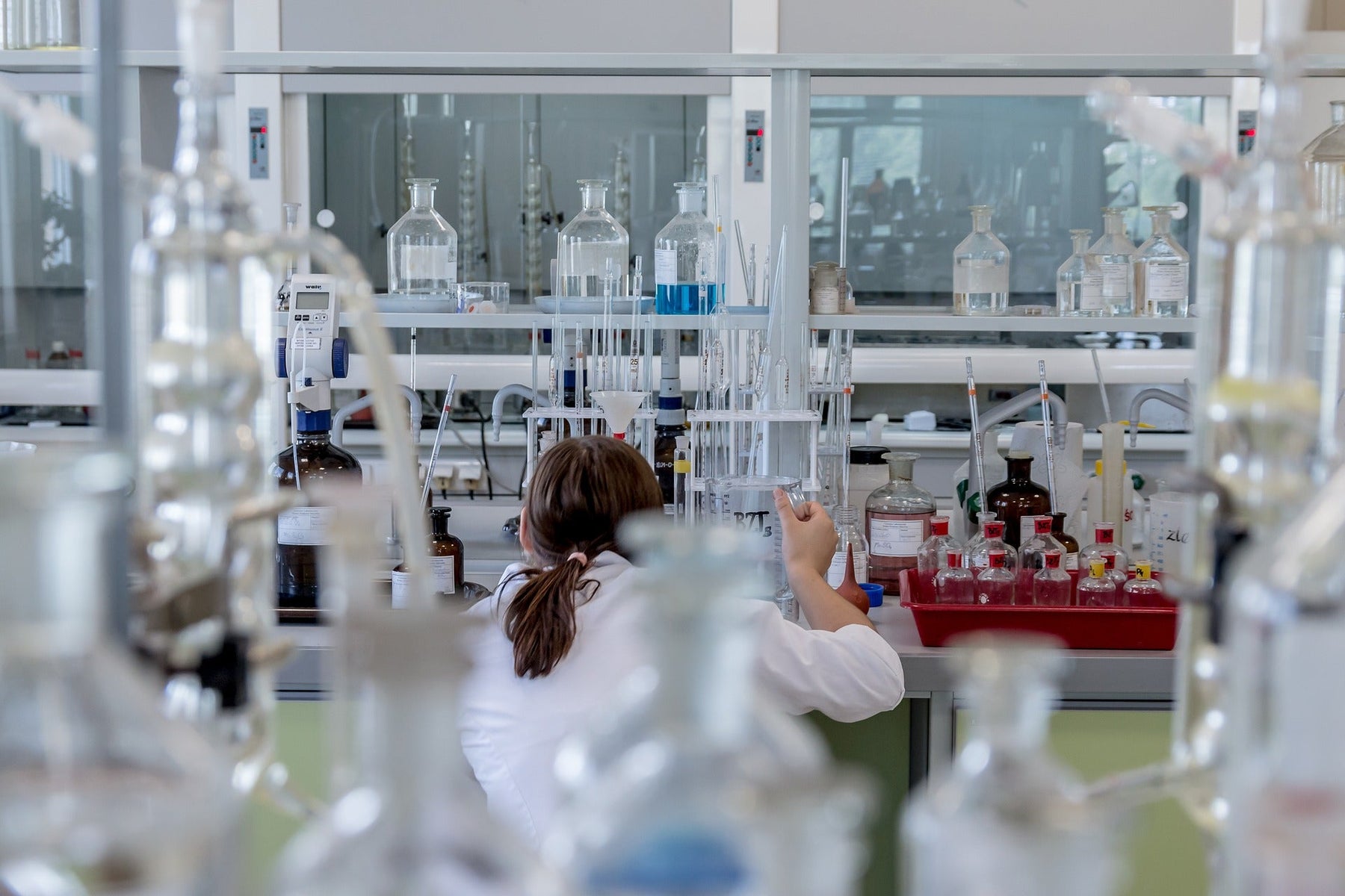 Woman in laboratory full of glass recipients