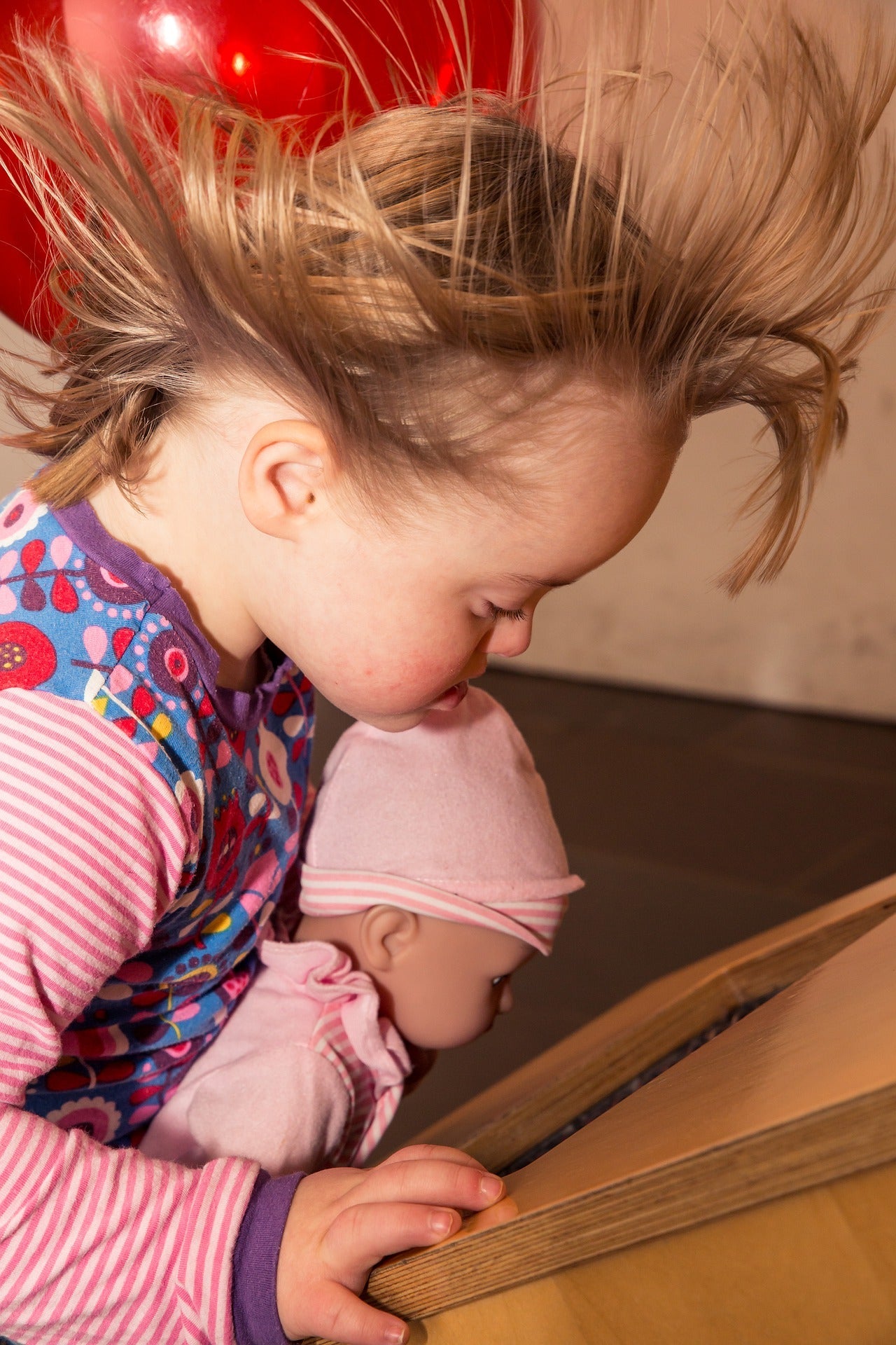 Girl with her doll getting wind in her hair