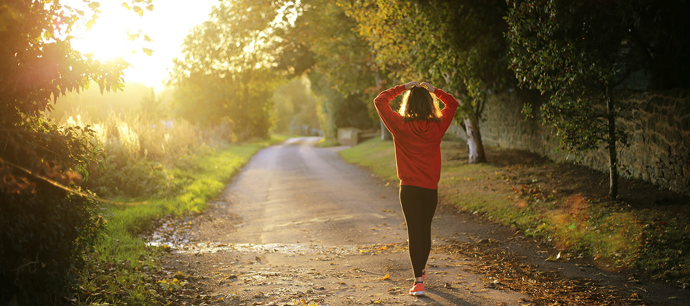 Girl in red sweater walking down a country road