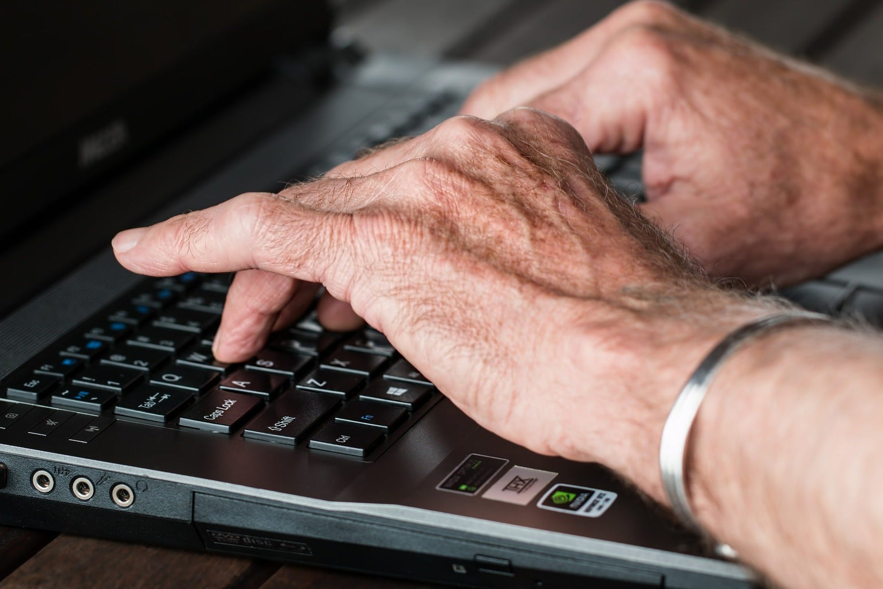 Hands writing on a black laptop