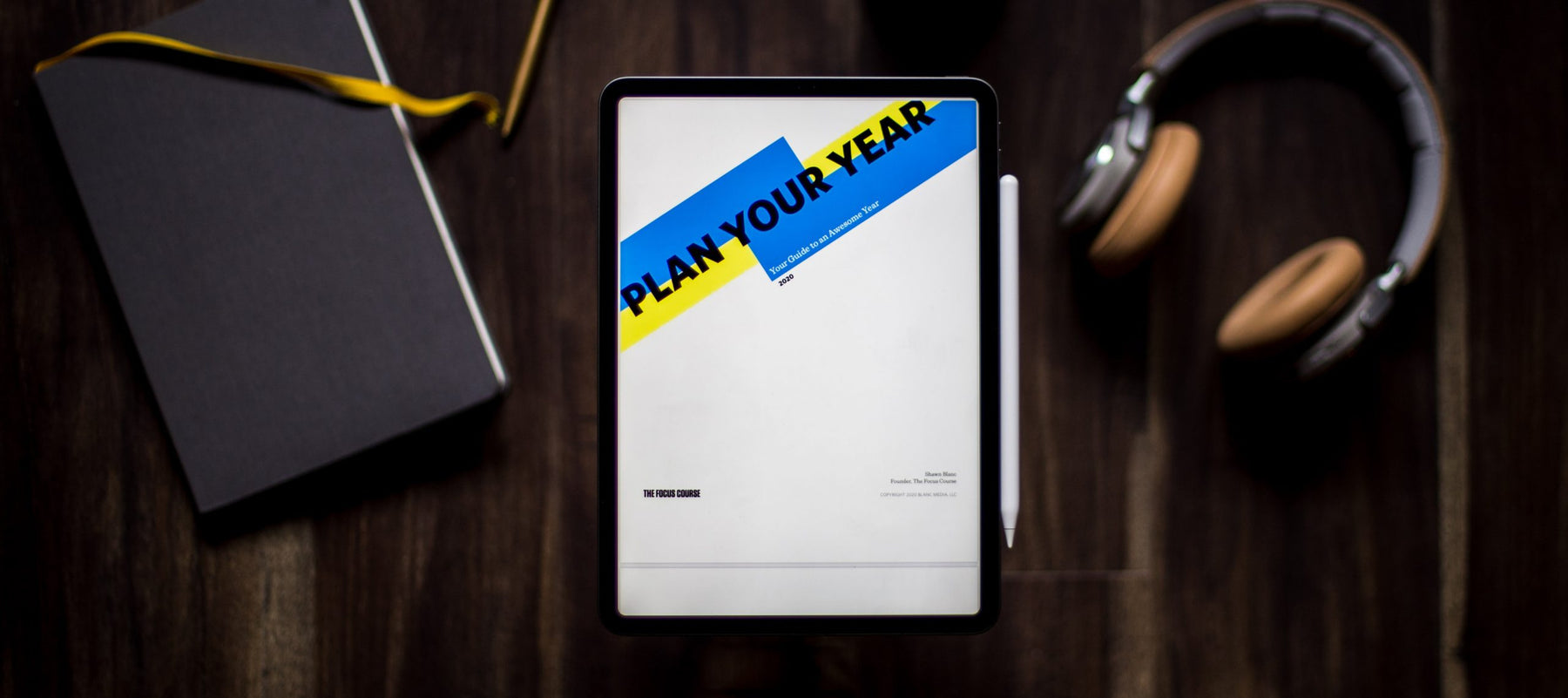 Desk with agenda, notebook and headphones