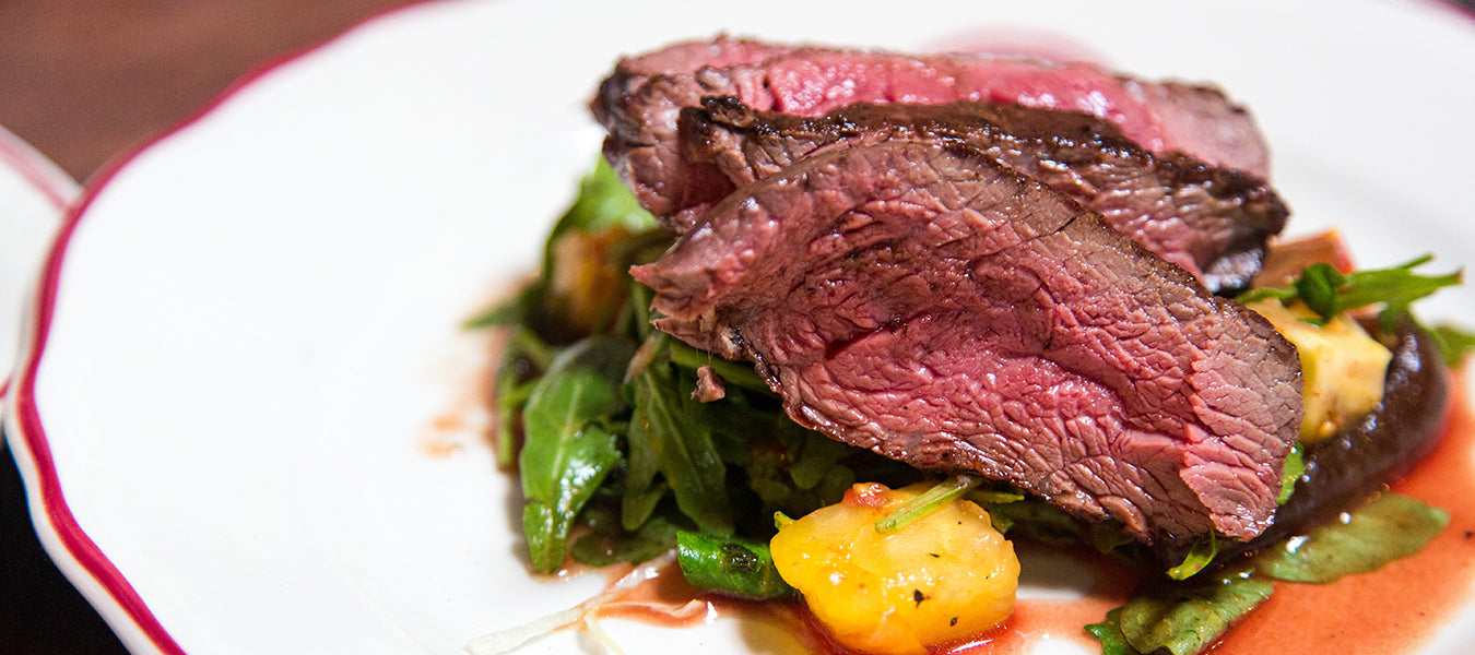 Rare steak with greens on a plate
