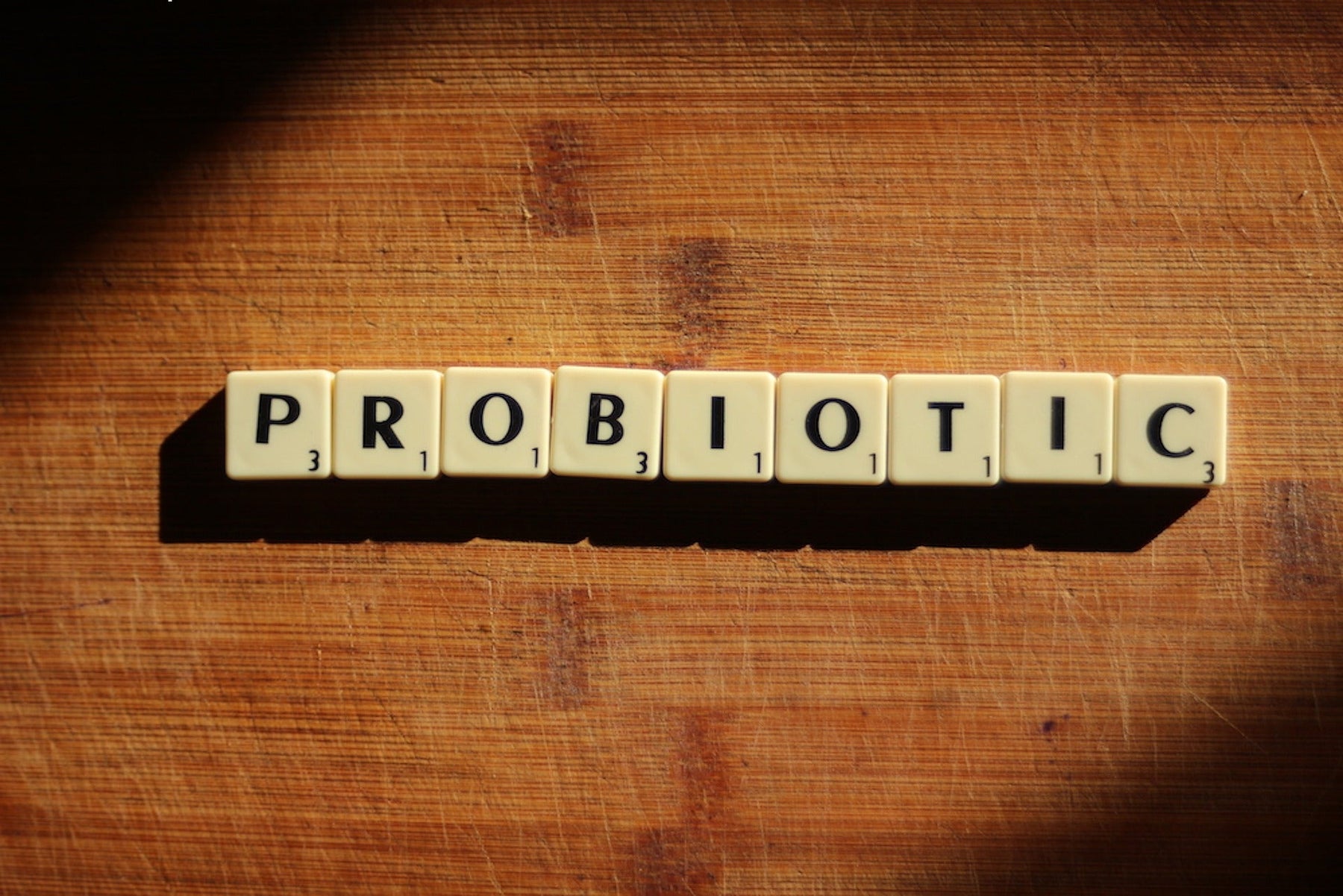 Rummy pieces on a wooden table reading probiotic
