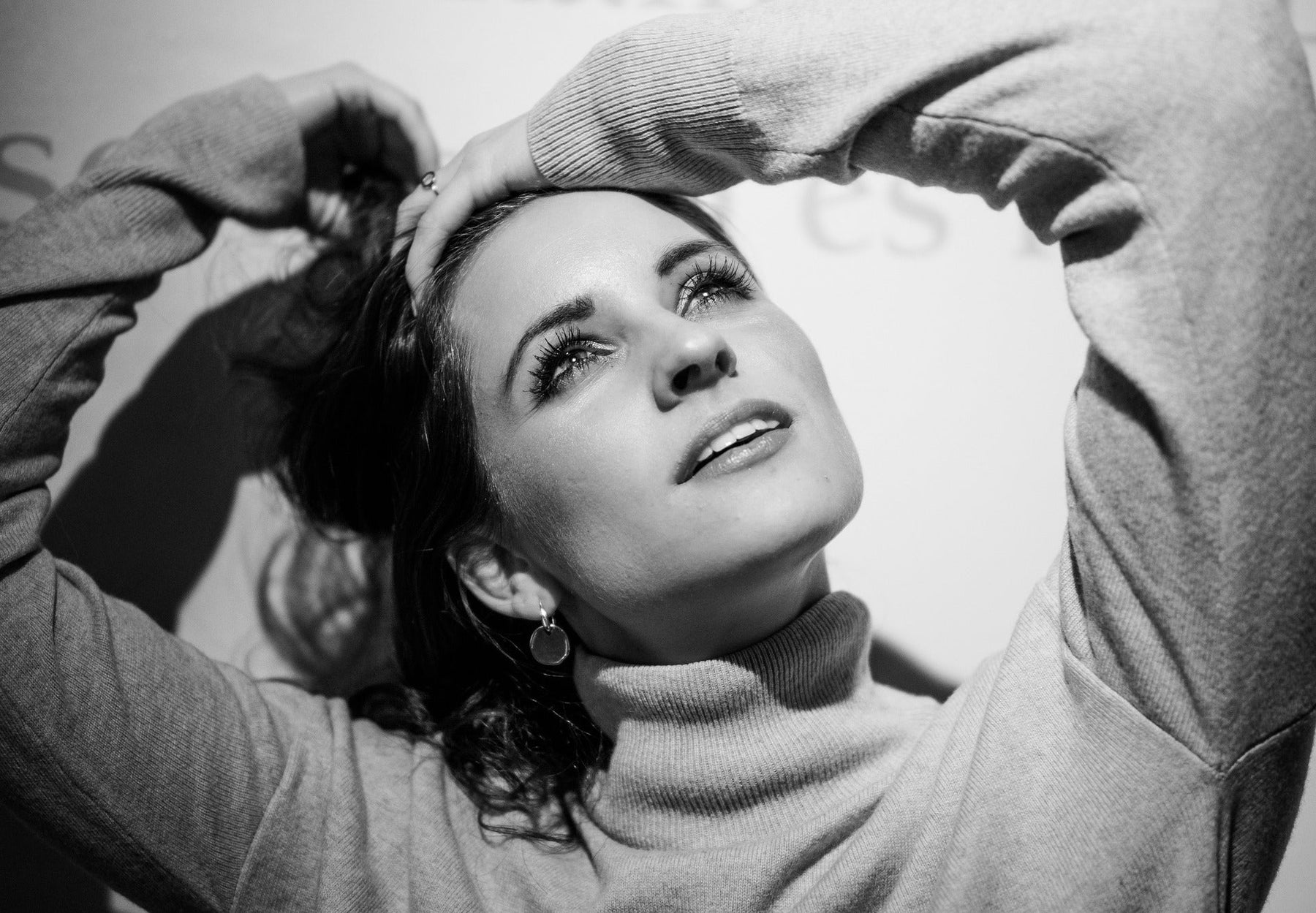 Happy woman with hand in her hair looking up