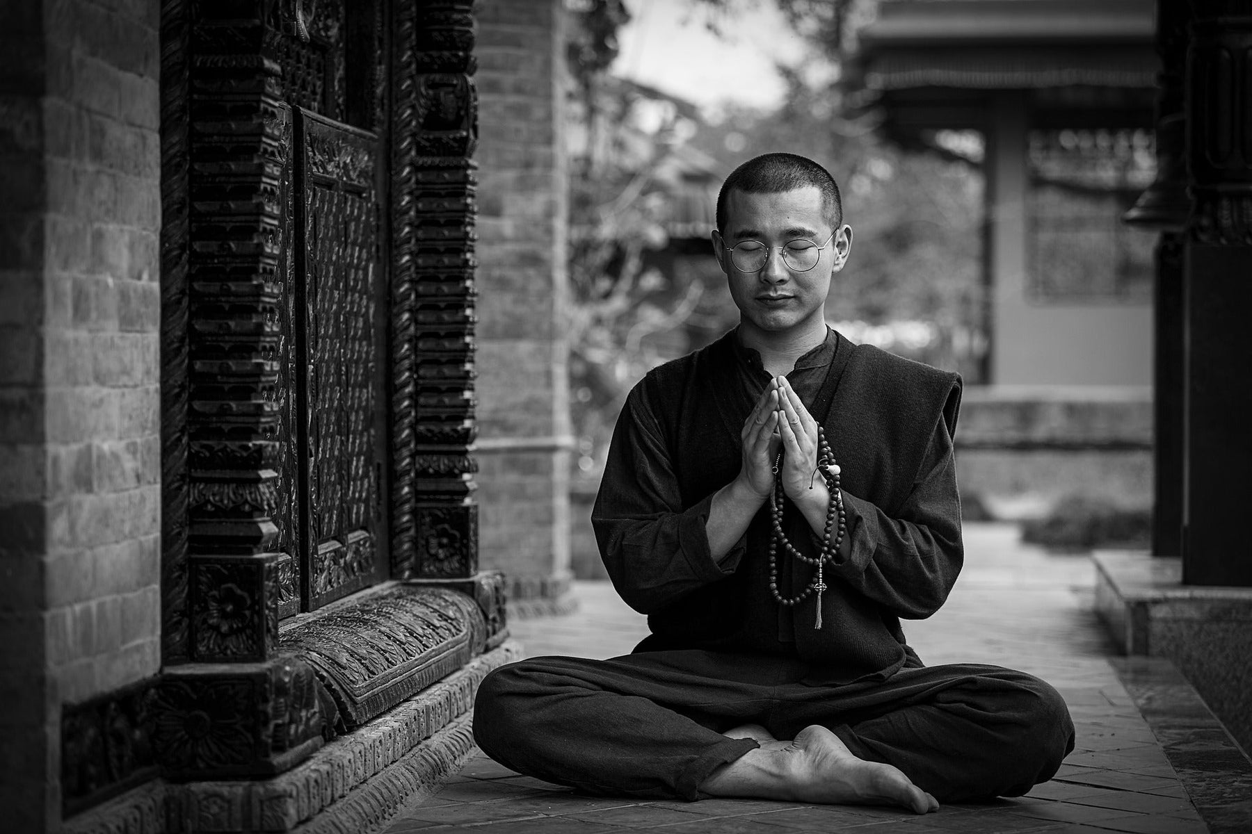 Man dressed in black doing yoga outside