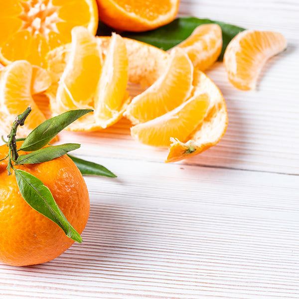 Whole clementine surrounded by pilled clementines