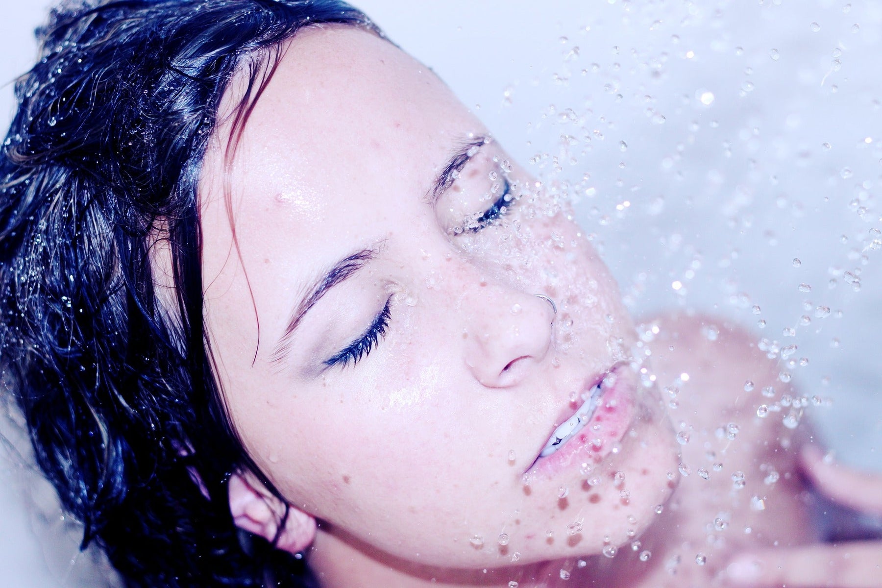 Brunette woman taking a shower with eyes closed