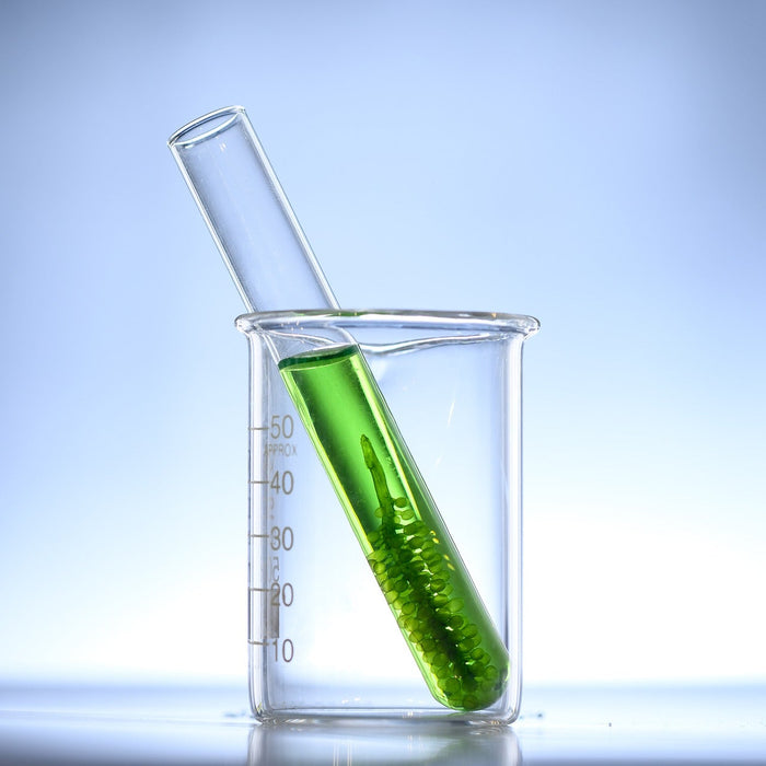 Recipient with green liquid into a glass recipient