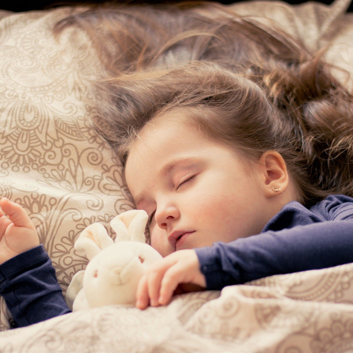 Little girl sleeping with her stuffed bunny