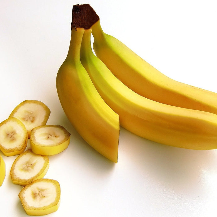 Three bananas one cut in half and sliced