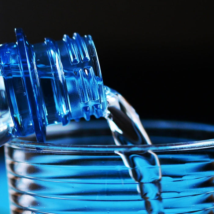 Bottle pouring water into a glass