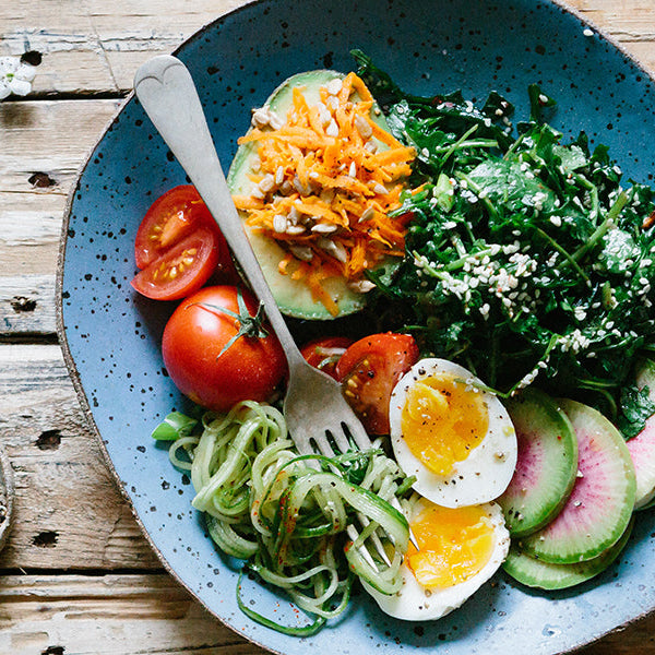 Healthy meal consisting of eggs, tomatoes and greens