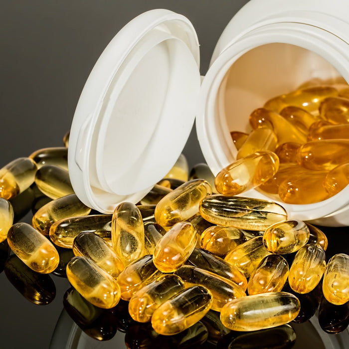 Fish oil pills dropping off a white bottle