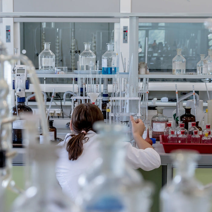 Woman in laboratory full of glass recipients