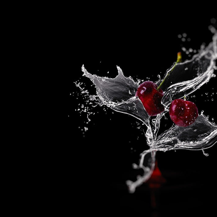 Two cherries with a splash of water on a black background