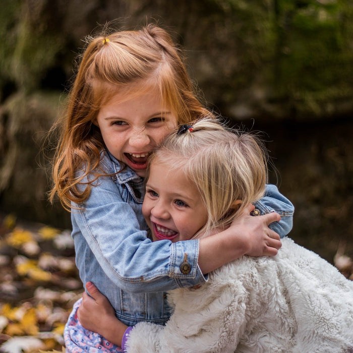 Two girls hugging and laughing