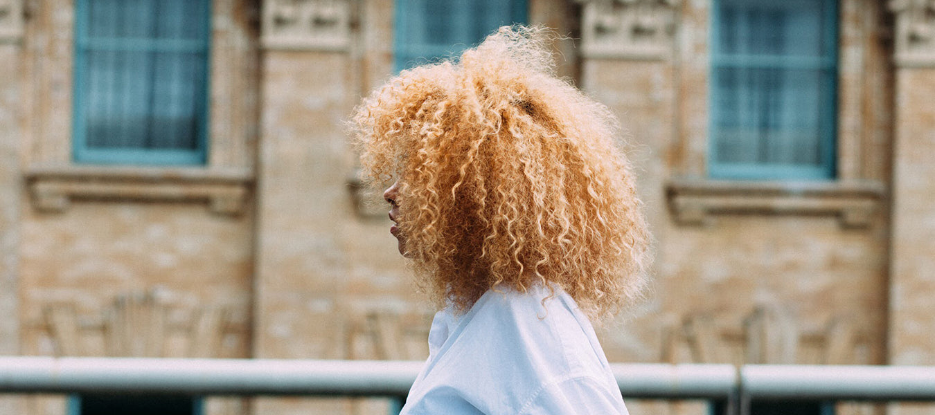 Curly woman in white shirt looking ahead