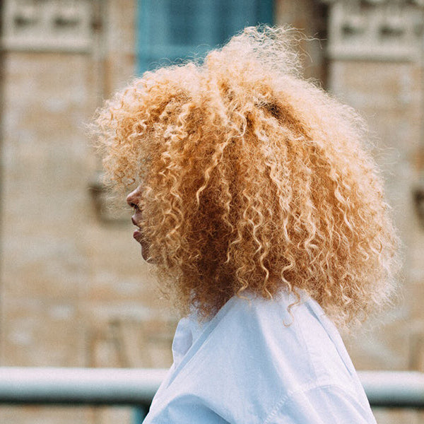 Curly woman in white shirt looking ahead