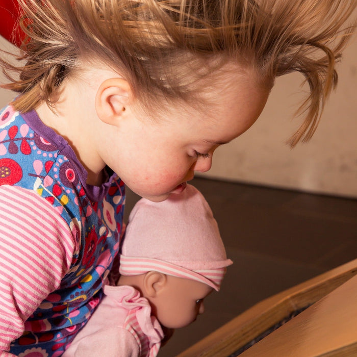 Girl with her doll getting wind in her hair