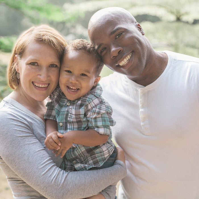 Happy man and woman holding their kid and smiling