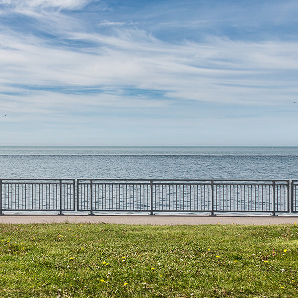 Woman running next to a beach and green field