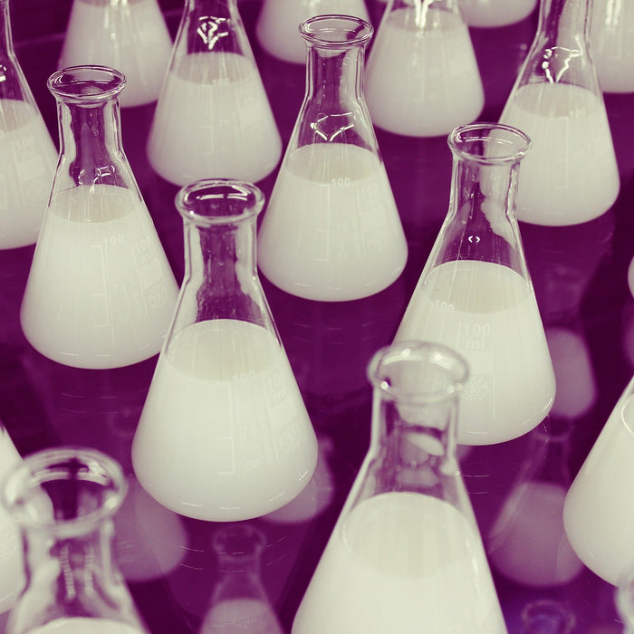 Multiple laboratory glasses with white liquid