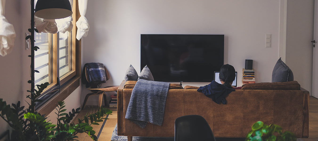 Man in a cozy room looking at a tv and relaxing