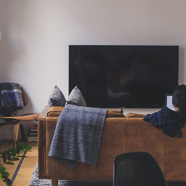 Man in a cozy room looking at a tv and relaxing