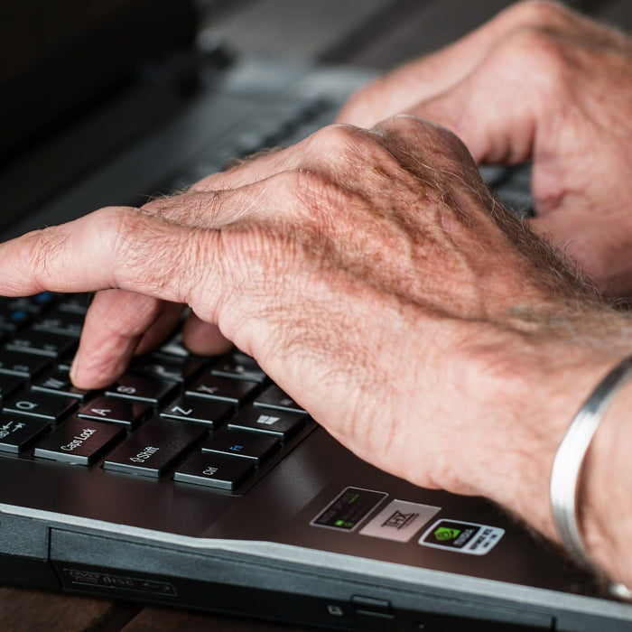 Hands writing on a black laptop