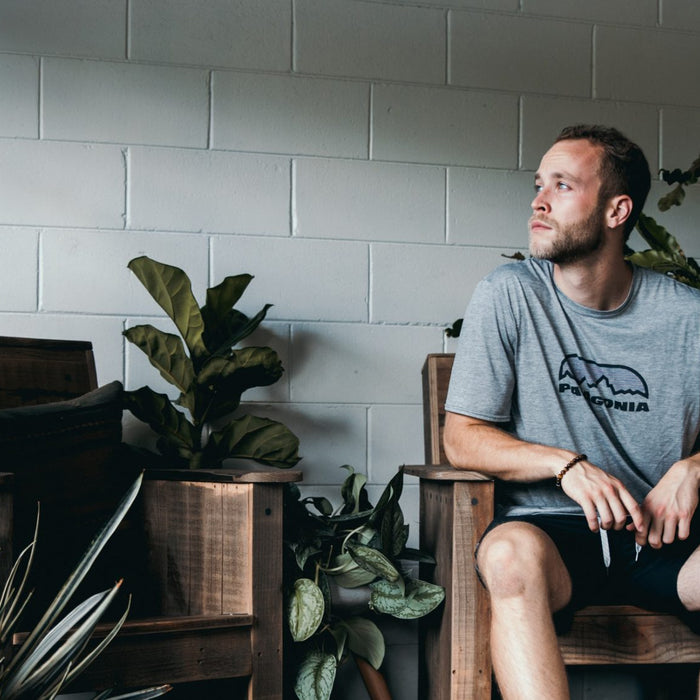 Man in shorts thinking and being surrounded by palnts