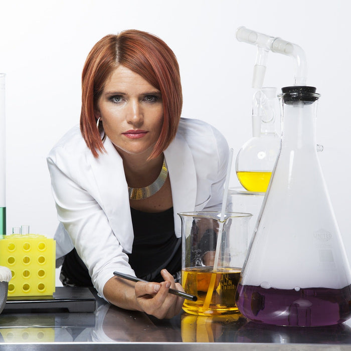 Woman surrounded by laboratory glasses looking at the camera