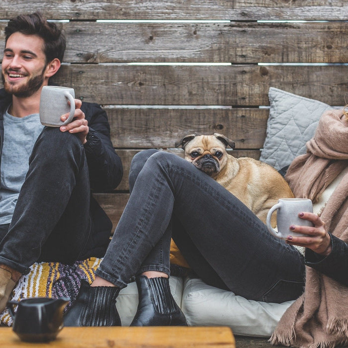 Man and woman outside with their dog sitting on the floor