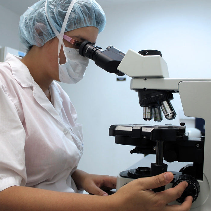 Laboratory woman looking through a microscope