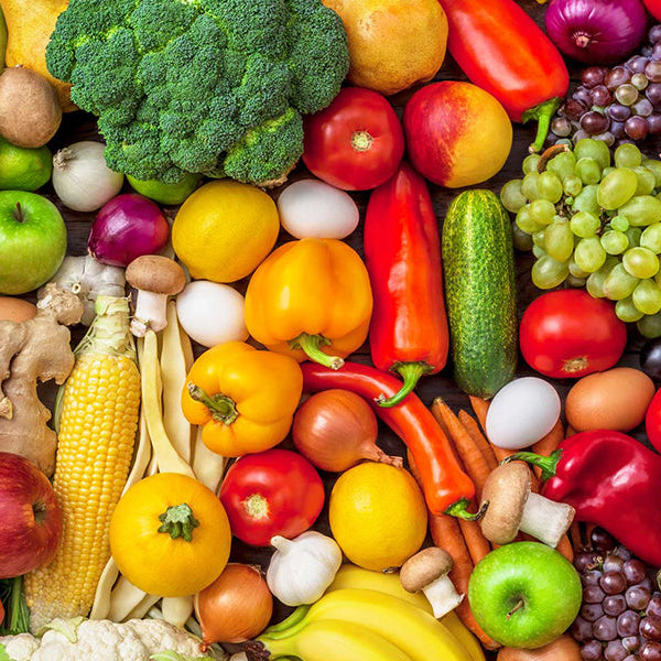 Place full of fruits and vegetables including yellow peppers, apples and onions