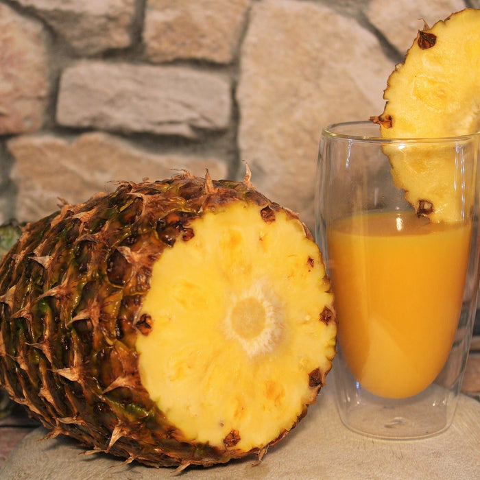 Cut pineapple along with a glass of pineapple juice