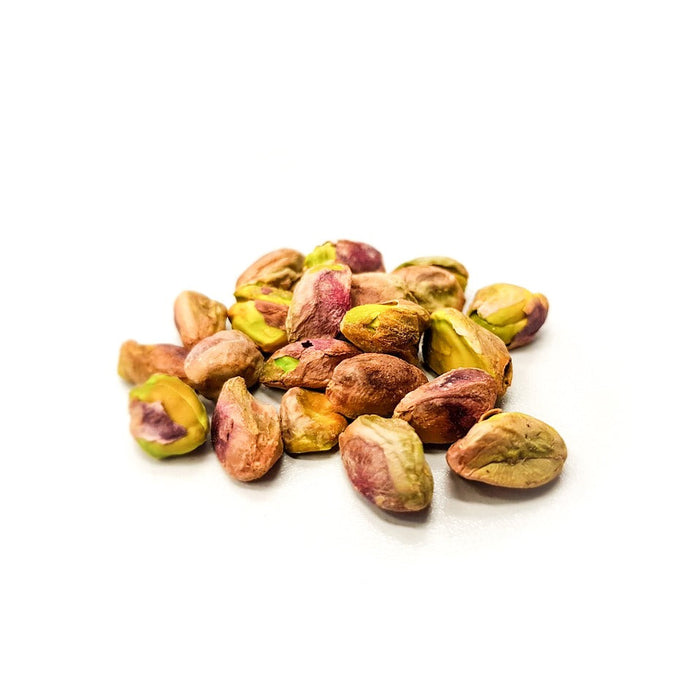 Pilled pistachio laying on a white surface