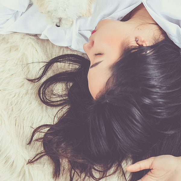 Brunette woman laying on a soft surface sleeping