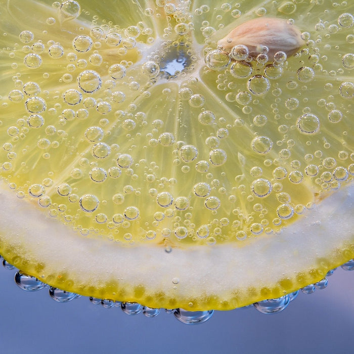 Drops of water poring down a slice of lemon