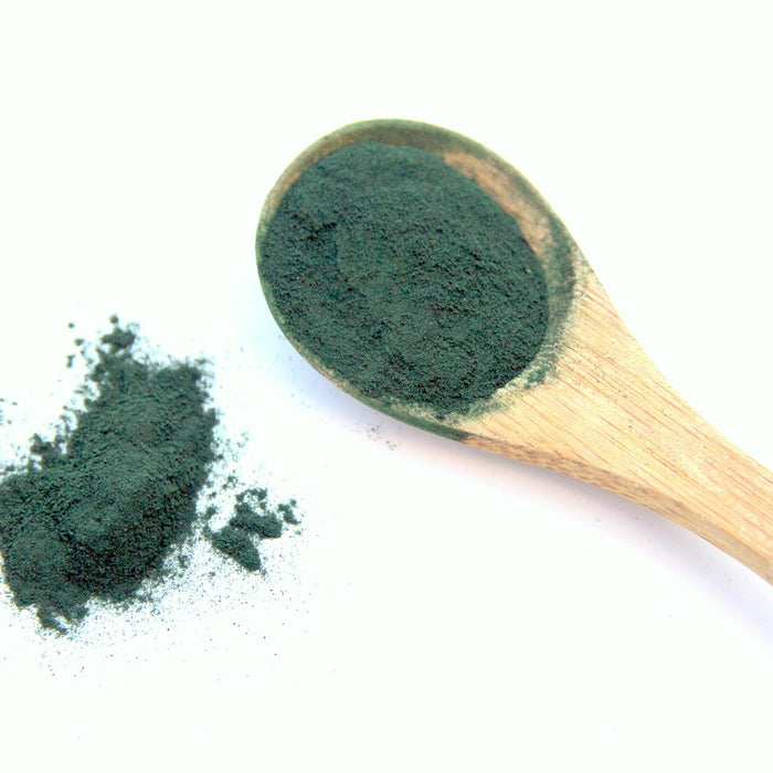 Green spirulina on a wooden spoon