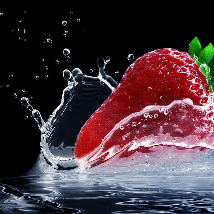 Strawberry dropping in water creating a splash