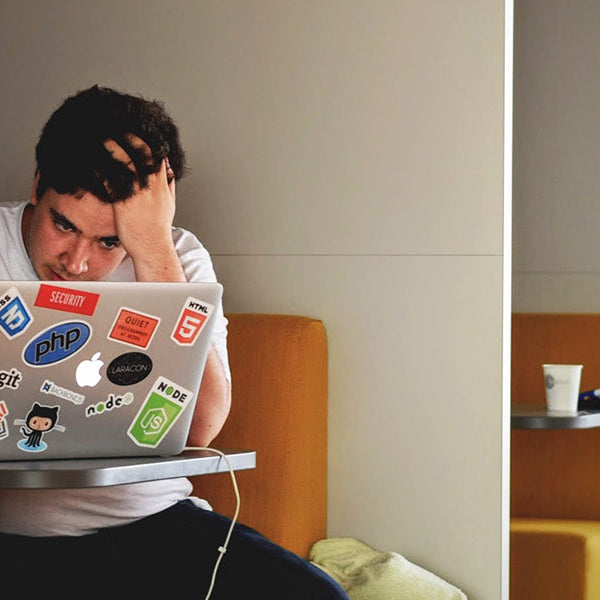 Young man stressing in a cubical watching his laptop
