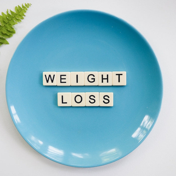 Leaf next to a blue plate that reads weight loss