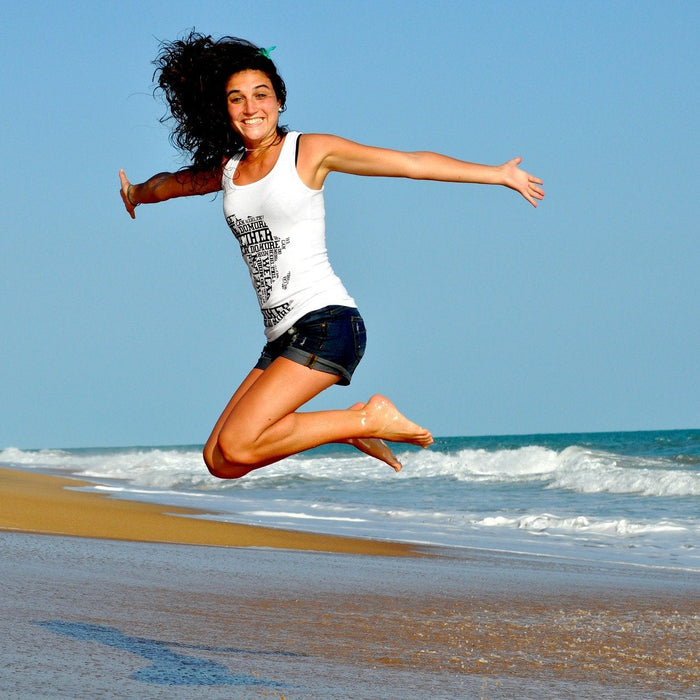 Happy woman jumping over a beach