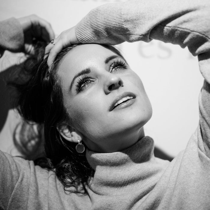 Happy woman with hand in her hair looking up