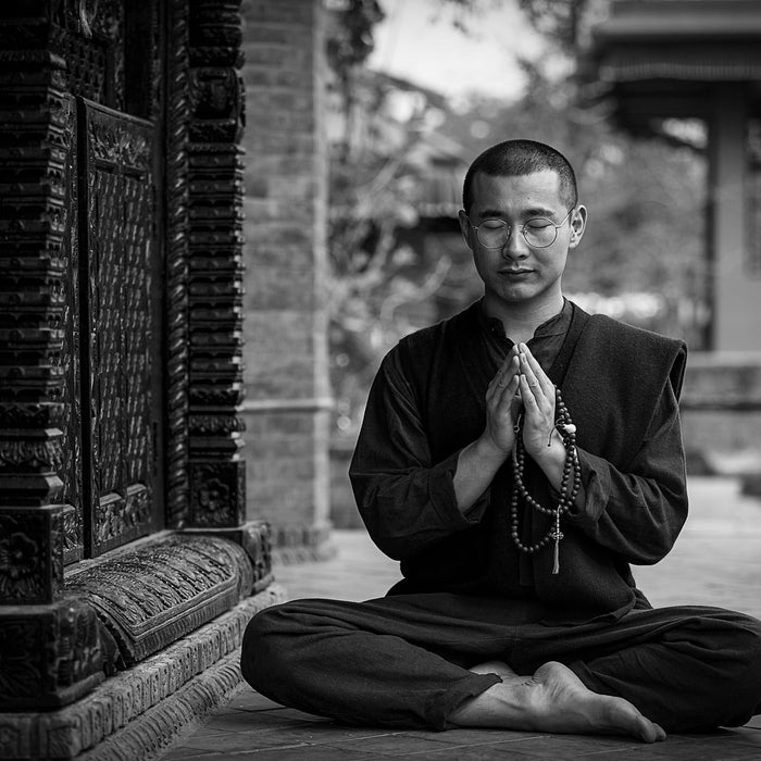 Man dressed in black doing yoga outside